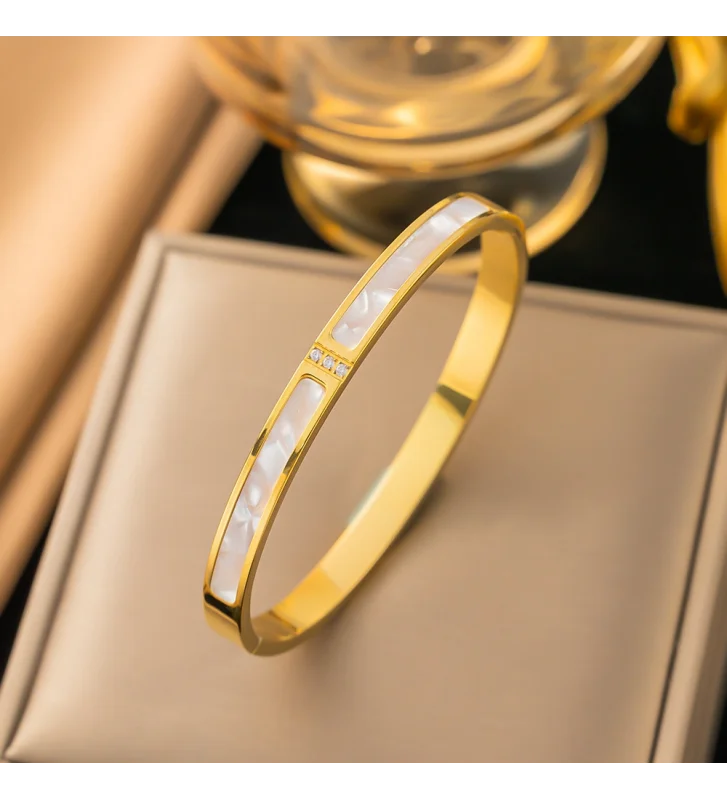 Brazalete Rígido Dorado con Detalles de Nácar y Pequeñas Gemas